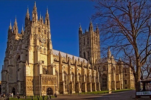 Canterbury Cathedral, a magnificent example of cathedrals in England, standing tall under a clear blue sky.