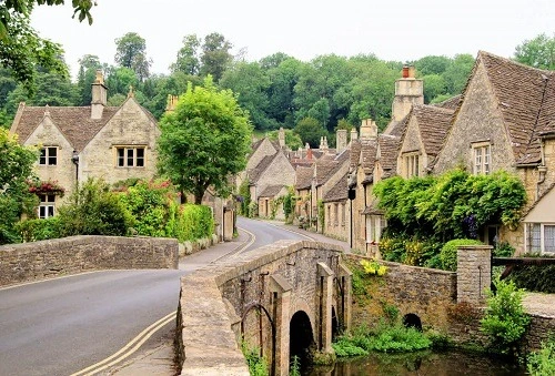 Charming English village scene featuring a stone bridge and cottages, one of many historic landmarks in England.